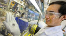 A scientist holding a battery.
