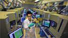 A scientists in a lab wearing protective eyewear and gloves.