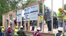 A dozen Brookhaven employees were part of the group that raised the first four walls on a home for veteran Kimberly Gilbreath and her teenage daughter Ryan.