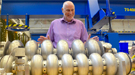 Andrew Hutton, associate director of Jefferson Lab’s Accelerator Division, looks over prototype particle accelerating devices – called cavities – in the lab’s Superconducting Radiofrequency Institute.