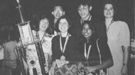 Left to right, in the back: Si Hwang Chin, Peter Chan, Renee Landrum. Front row: coach Penny Sconzo, Susan Born, and Shireen Haque with their 1994 National Science Bowl® trophy.