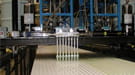 Using a machine developed and tested at Argonne National Laboratory, technicians apply special no-drip glue to a NOvA panel to create blocks that are 16 meters by 16 meters square and weigh 200 tons.