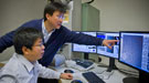 Two scientists in the lab looking at computer monitors