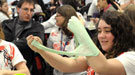 A young female student experimenting with green goo