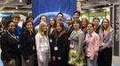 Group of students and teachers gathered in front of an Office of Science exhibit