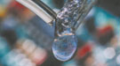 A soldering iron touching the end of a wire producing a droplet