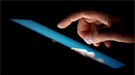 A hand hovering over a touchscreen.