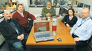 Team of engineers sitting around a table with the MINDS device
