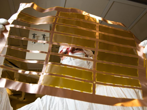 Pacific Northwest National Laboratory chemist Isaac Arnquist examines the ‘coupons’ of ultra-low radiation copper cables specially created for sensitive physics detection experiments. 